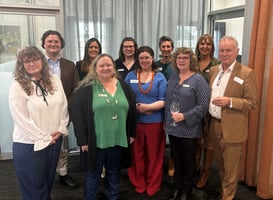 A group of 10 people standing in two rows facing the camera.