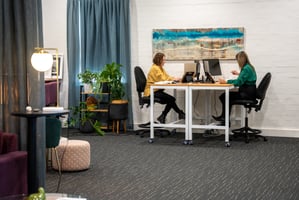 Two women working at computers in a decorated office